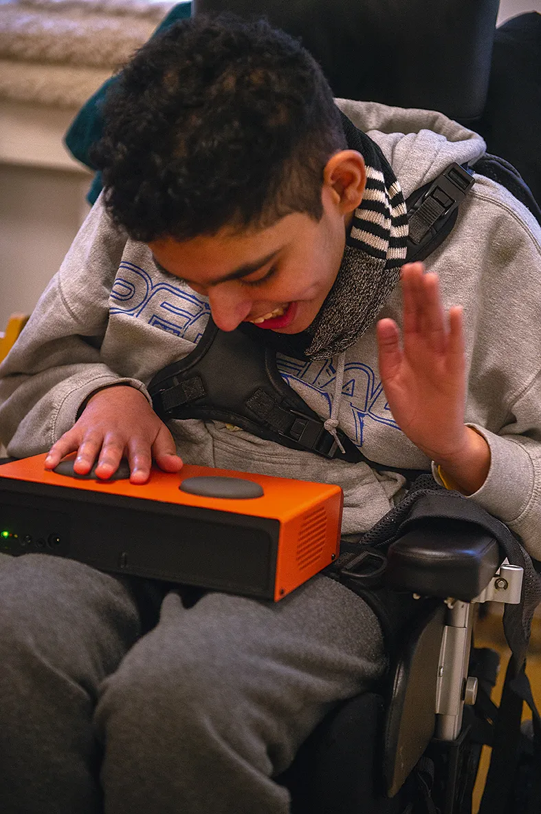 Ung man i rullstol spelar på ett orange Funki-instrument