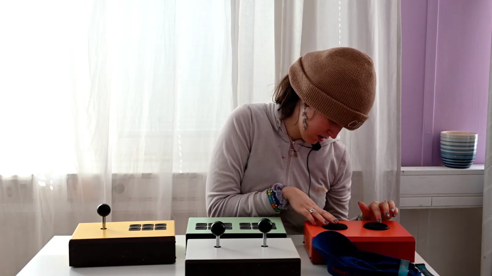 Ung kvinna spelar på flera Funki-instrument vid fönstret