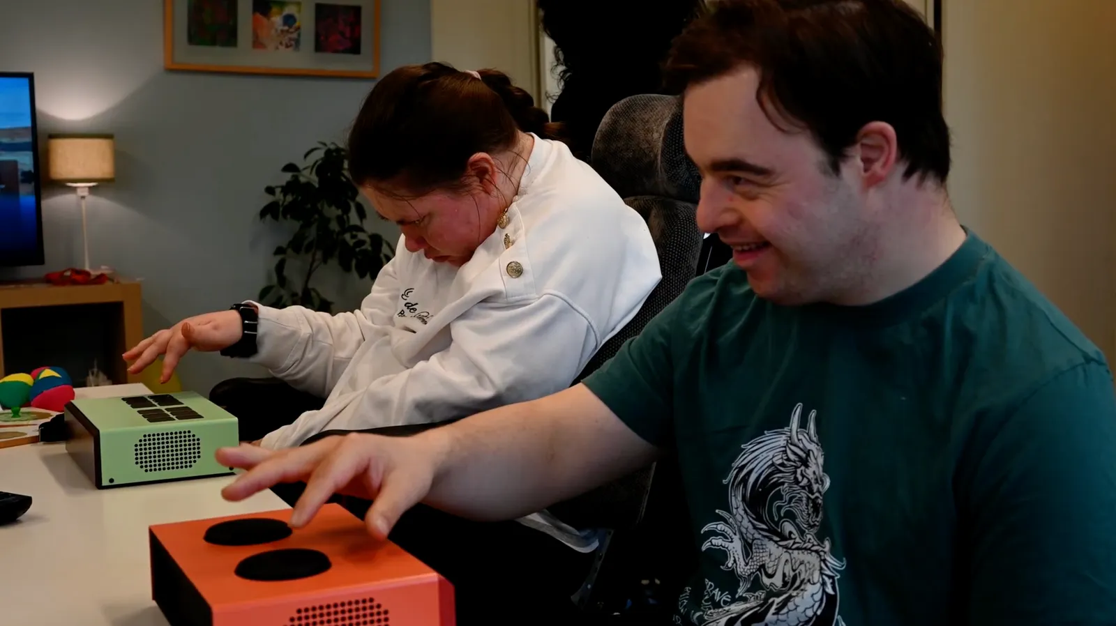 Två personer spelar på Funki-instrument vid ett bord